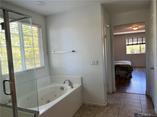 bathroom featuring plus walk in shower, a wealth of natural light, and tile patterned floors