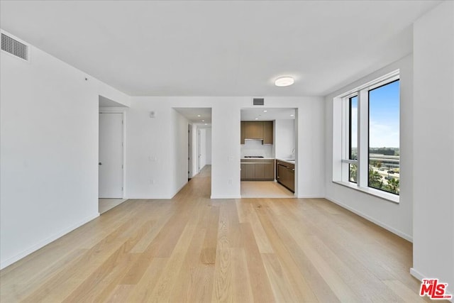 unfurnished living room featuring light hardwood / wood-style floors and sink