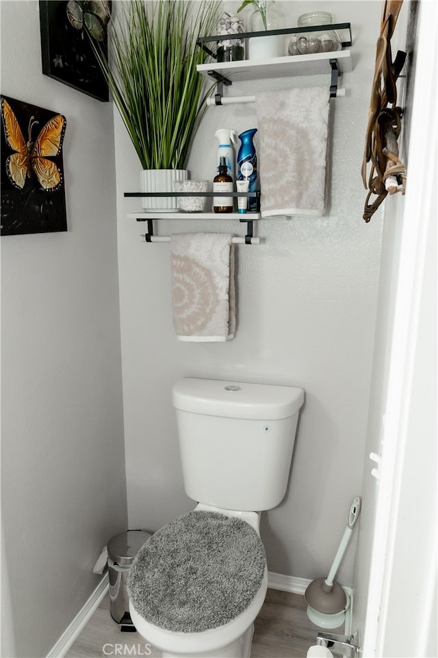 bathroom with hardwood / wood-style flooring and toilet