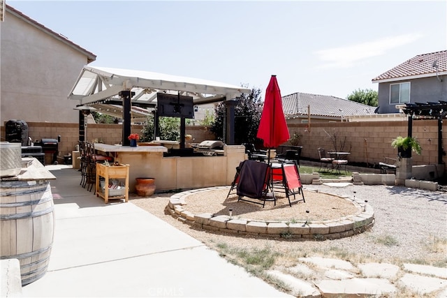 exterior space featuring an outdoor fire pit, a patio area, and a bar