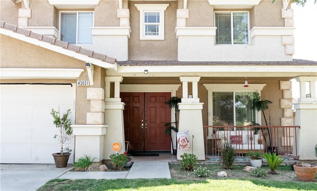 entrance to property featuring covered porch and a garage