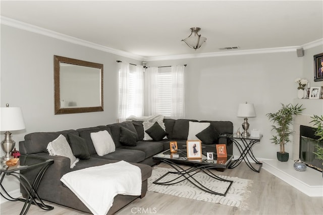 living room with crown molding and light hardwood / wood-style flooring