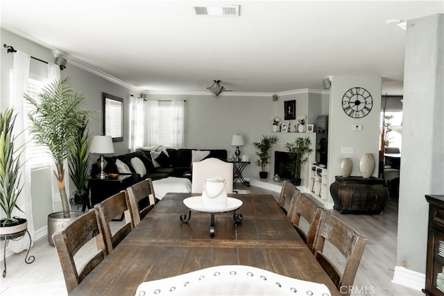 dining room with wood-type flooring and ornamental molding