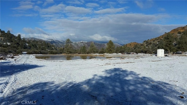 yard covered in snow with a water and mountain view