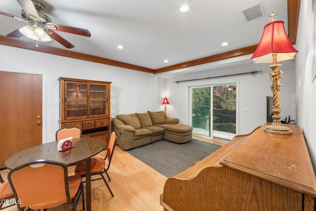 living room featuring light hardwood / wood-style floors, ceiling fan, and crown molding