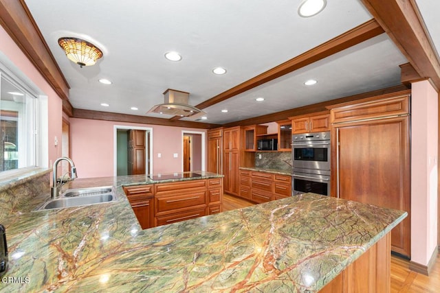 kitchen featuring kitchen peninsula, island exhaust hood, tasteful backsplash, black appliances, and sink