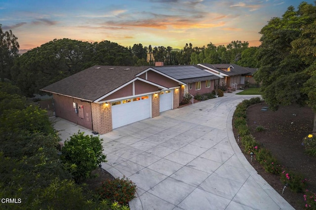 ranch-style home with solar panels and a garage