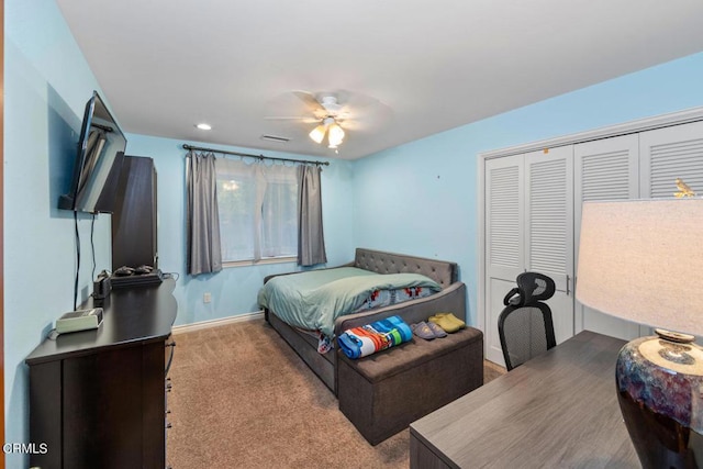 bedroom featuring ceiling fan, a closet, and light carpet