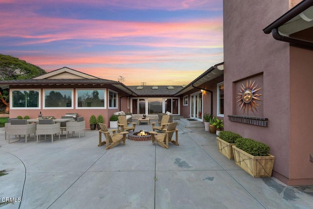 patio terrace at dusk featuring a fire pit