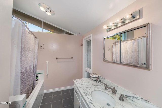 bathroom featuring tile patterned floors, vanity, a healthy amount of sunlight, and lofted ceiling