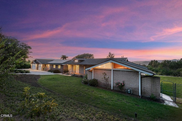 exterior space featuring solar panels, a yard, and a garage