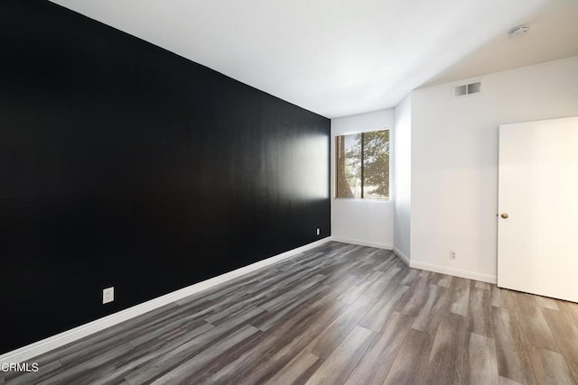 spare room featuring wood-type flooring