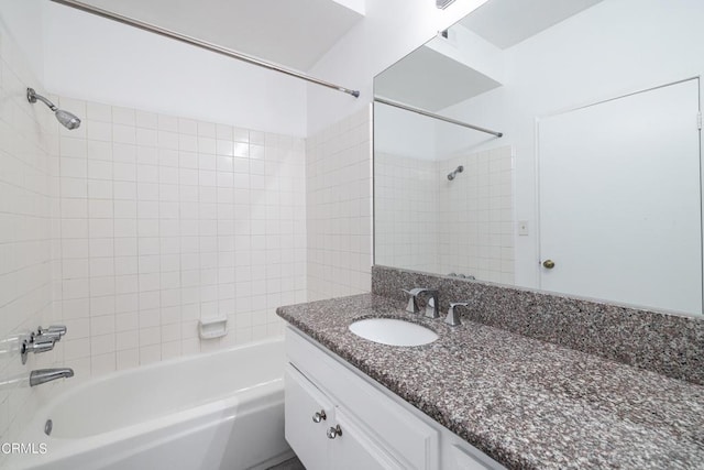 bathroom with tiled shower / bath combo and vanity