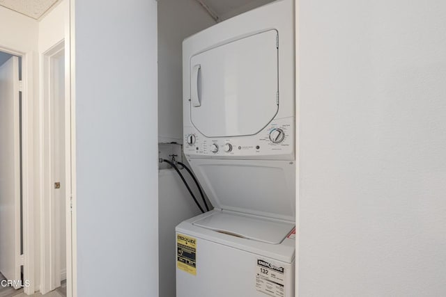 clothes washing area with stacked washer and clothes dryer