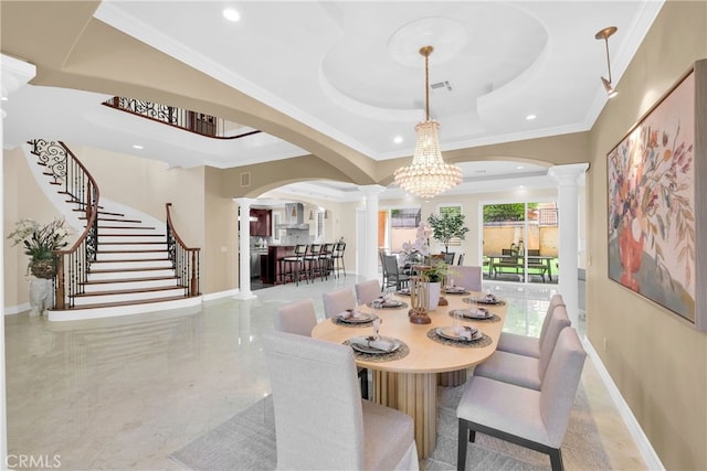 dining space featuring a raised ceiling, decorative columns, ornamental molding, and a notable chandelier