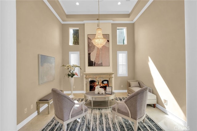 dining area featuring crown molding, a high ceiling, a tray ceiling, and a high end fireplace