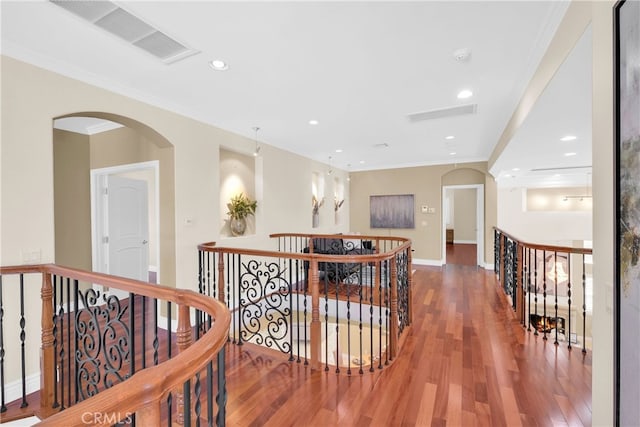 hall featuring wood-type flooring and crown molding