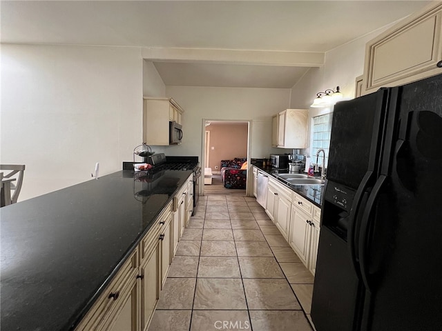 kitchen featuring cream cabinetry, light tile patterned floors, beamed ceiling, black appliances, and sink