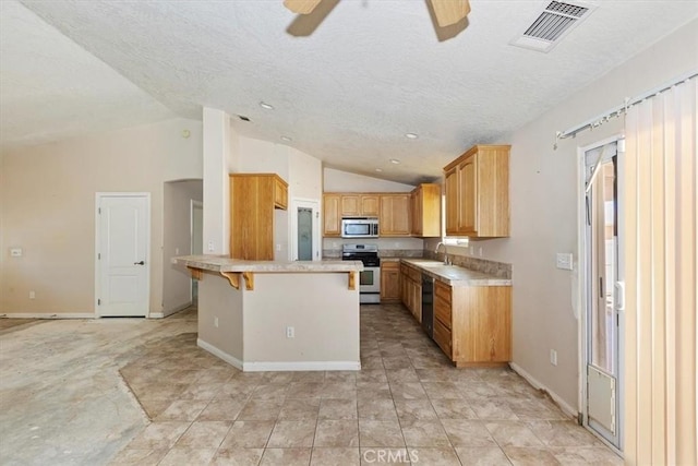 kitchen with a kitchen bar, stove, lofted ceiling, and sink