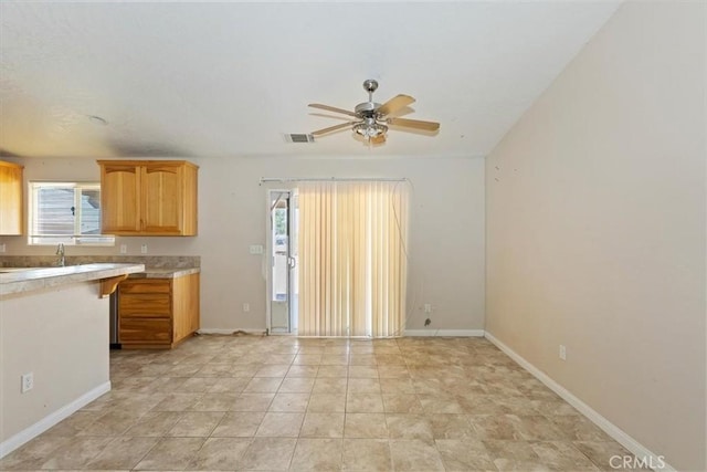 kitchen featuring ceiling fan and sink