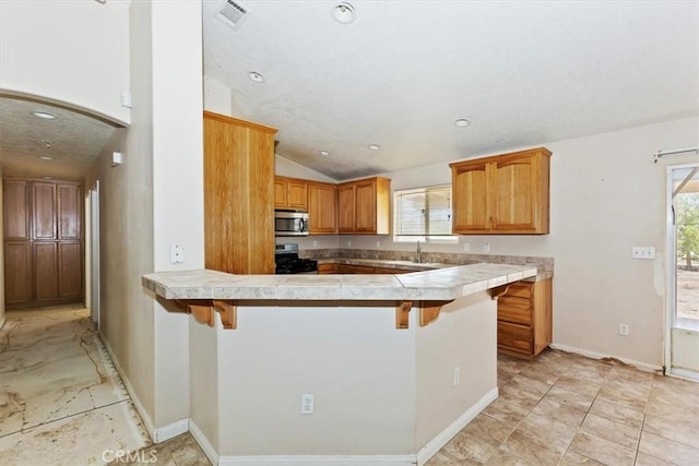 kitchen featuring a breakfast bar, stainless steel appliances, and plenty of natural light