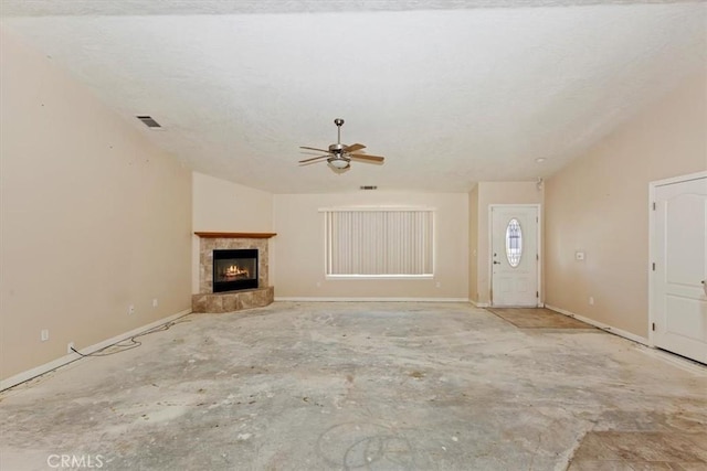 unfurnished living room with ceiling fan, vaulted ceiling, and a tiled fireplace