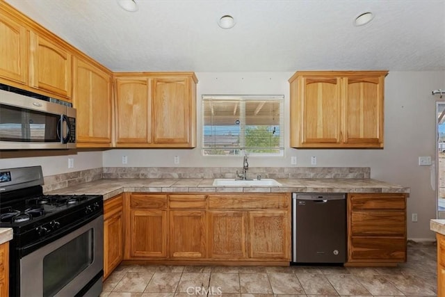 kitchen featuring sink, light tile patterned floors, and stainless steel appliances