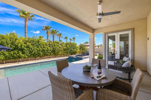 view of patio with ceiling fan, a swimming pool with hot tub, and french doors