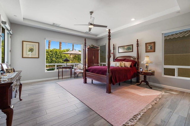 bedroom with a raised ceiling and ceiling fan