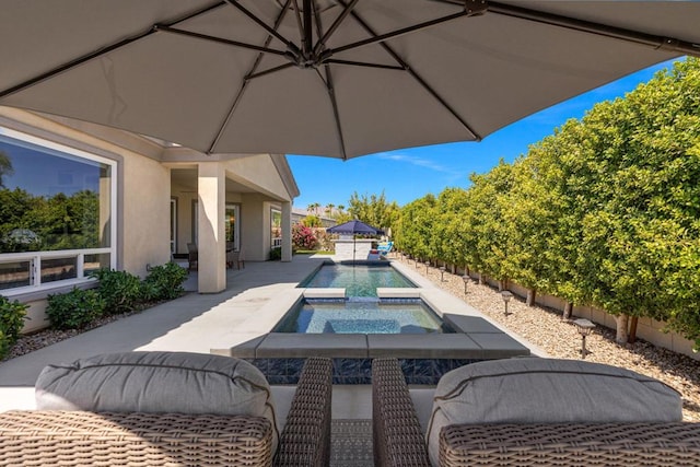 view of patio with a pool with hot tub