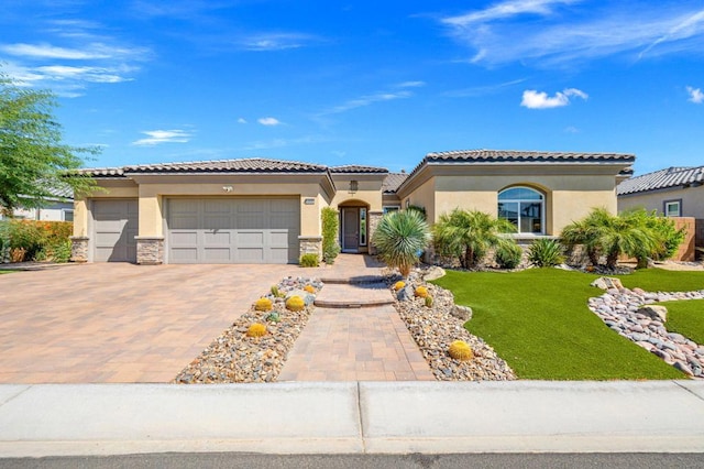 mediterranean / spanish-style home featuring a garage and a front lawn