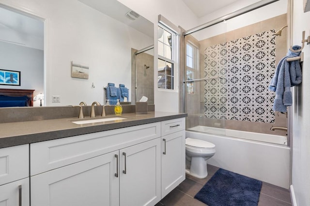 full bathroom featuring tile patterned floors, enclosed tub / shower combo, vanity, and toilet