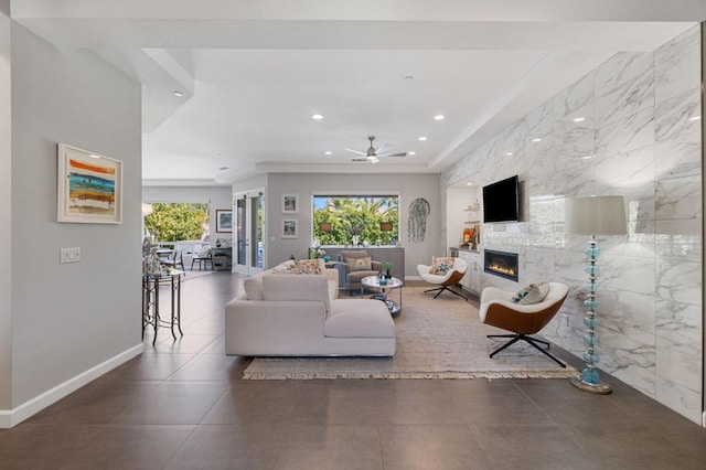 living room with ceiling fan and a large fireplace