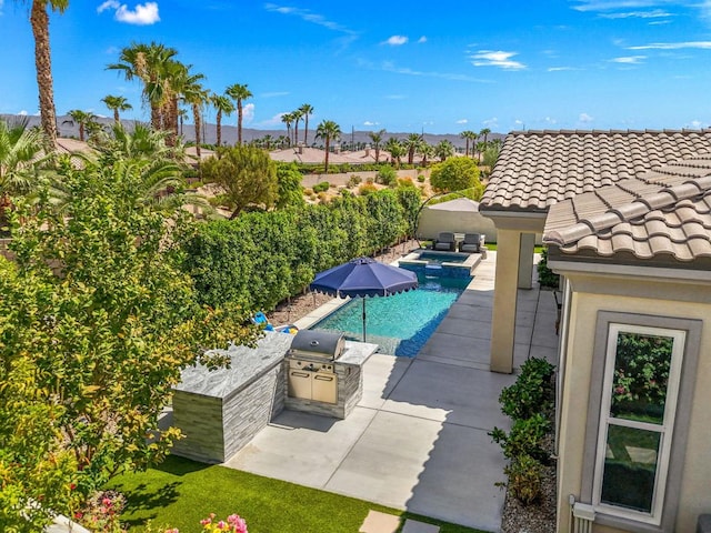 view of swimming pool featuring area for grilling, an in ground hot tub, exterior kitchen, and a patio