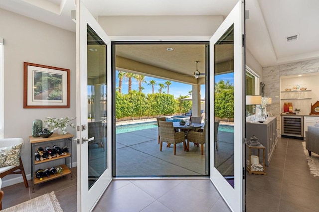 doorway to outside featuring beverage cooler, french doors, and dark tile patterned flooring