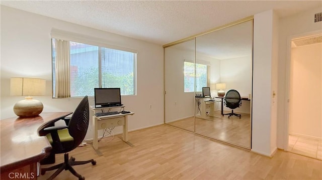 office with wood-type flooring and a textured ceiling