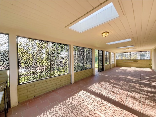 unfurnished sunroom featuring a skylight and a wealth of natural light