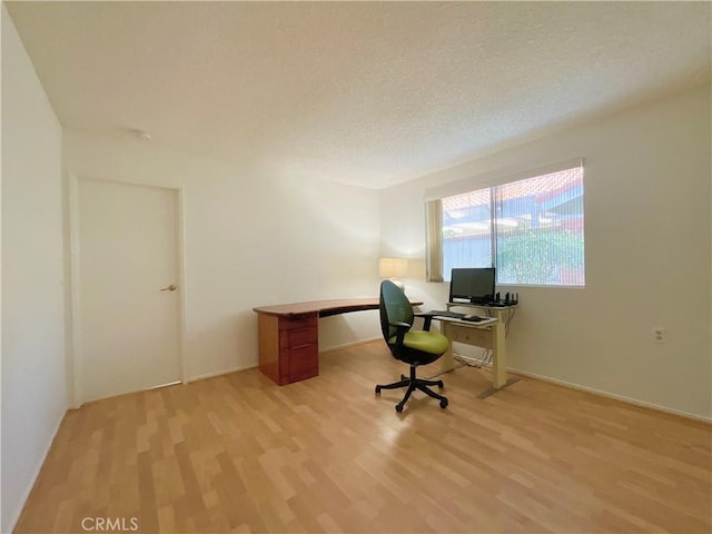 unfurnished office with a textured ceiling and light hardwood / wood-style flooring