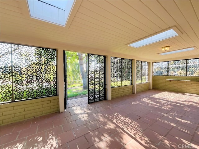 unfurnished sunroom featuring a skylight and a healthy amount of sunlight