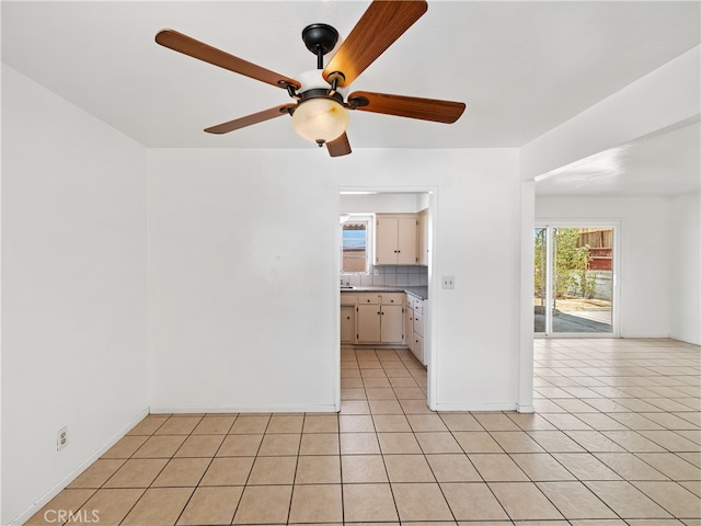 tiled spare room featuring ceiling fan