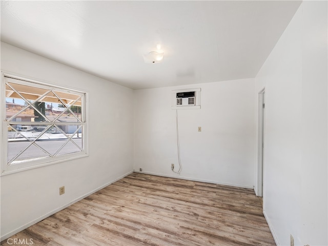 spare room featuring light wood-type flooring and a wall mounted AC