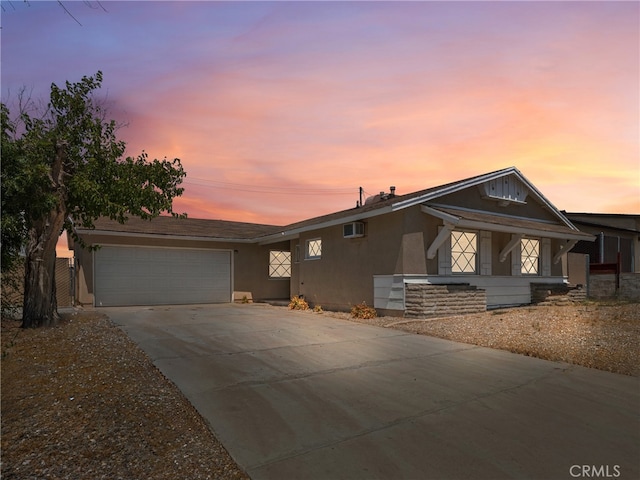 view of front of property featuring a garage and a wall mounted air conditioner