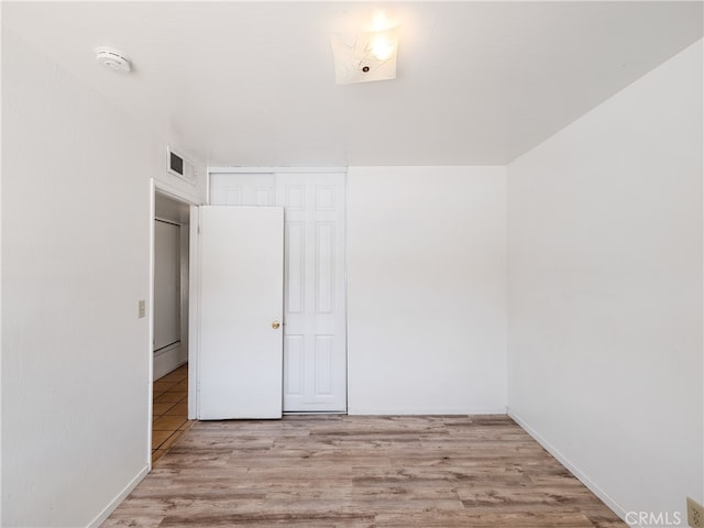 unfurnished bedroom featuring light hardwood / wood-style flooring and a closet