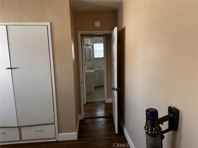 hallway featuring sink and dark wood-type flooring