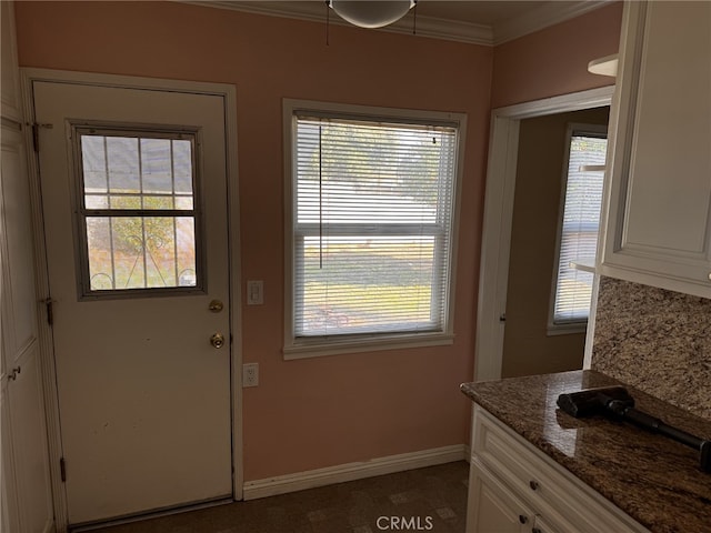 entryway with ornamental molding and a wealth of natural light