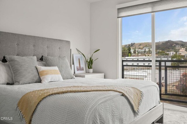 bedroom with a mountain view and access to outside