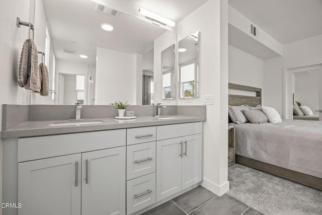 ensuite bathroom featuring visible vents, connected bathroom, a sink, and double vanity