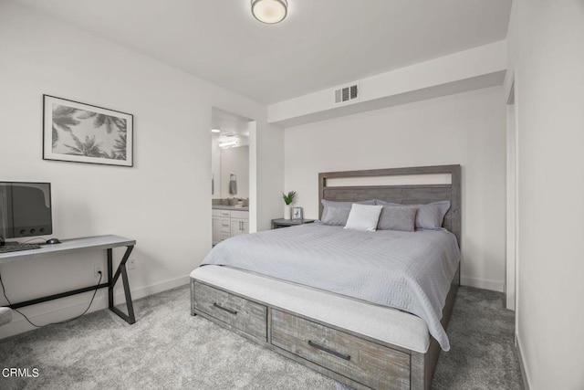 carpeted bedroom featuring baseboards, visible vents, and ensuite bathroom