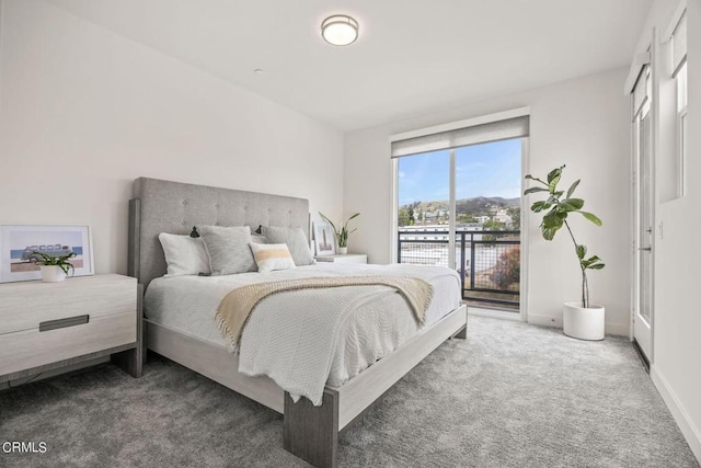 carpeted bedroom featuring baseboards and access to exterior