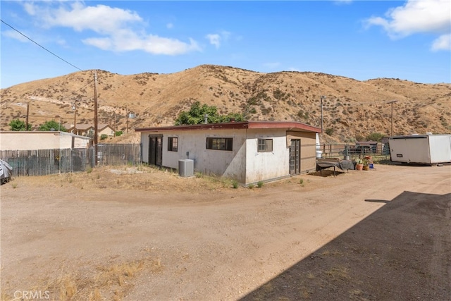 back of house featuring a storage unit, a mountain view, and central air condition unit